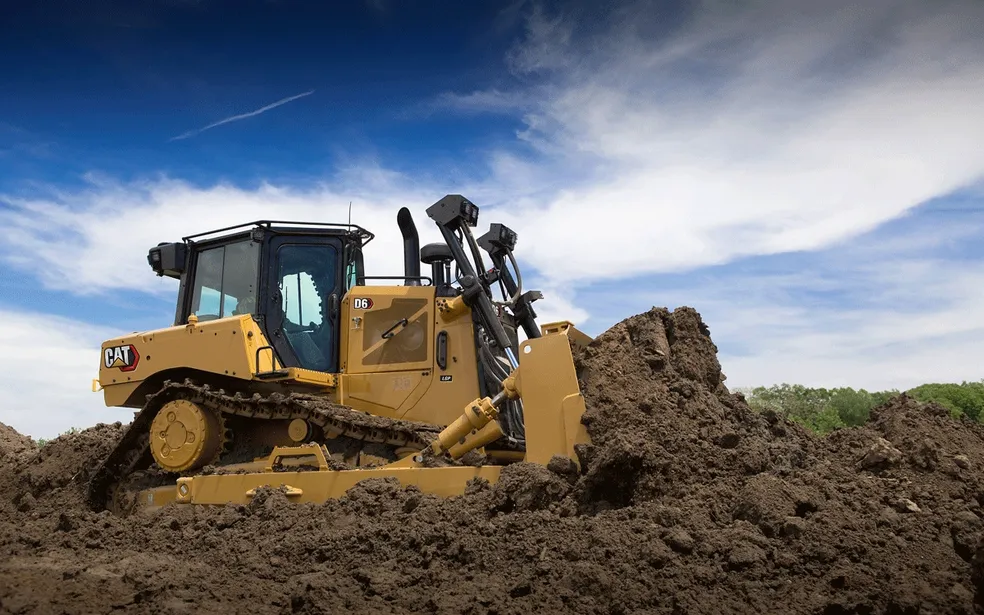 CAT dozer clearing land and pushing dirt for construction site preparation